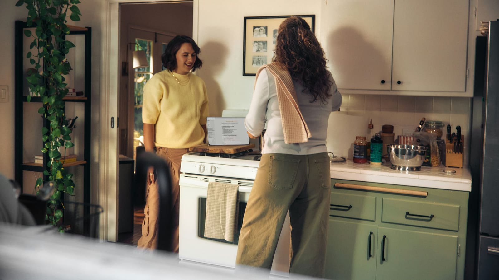 two people and a laptop in a kitchen